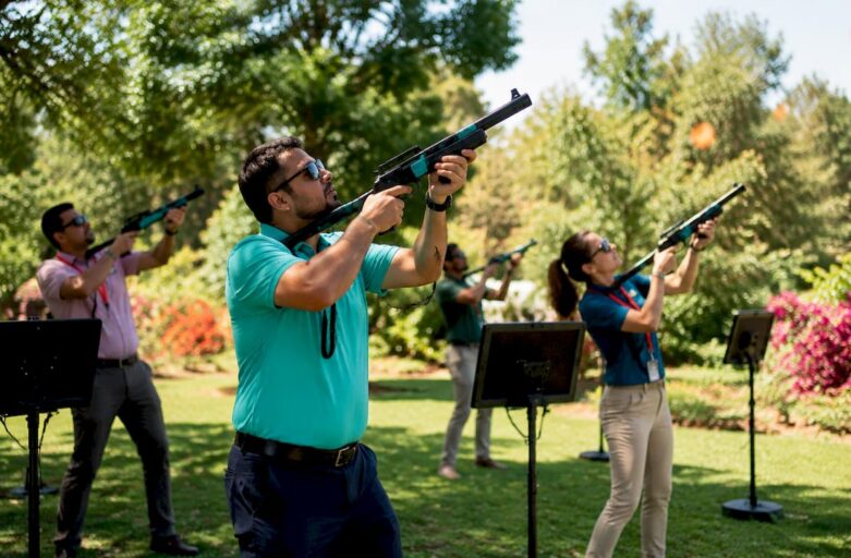 Group engaging in laser clay shooting outdoors