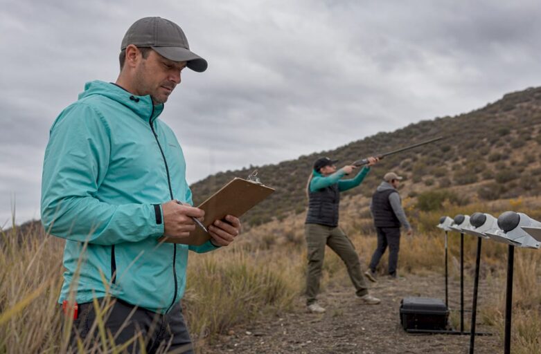 Event planner assessing weather at outdoor clay shooting range