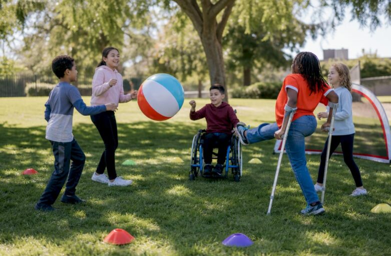 Children playing inclusive outdoor sports on school field