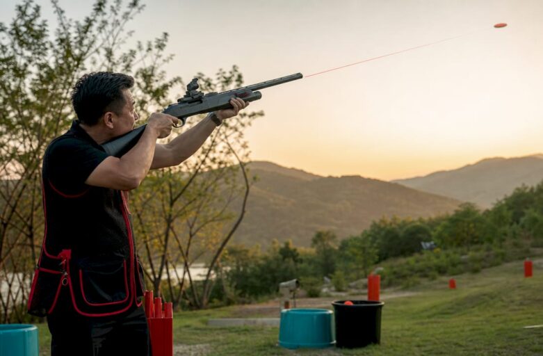 Athlete aiming at laser clay target indoors