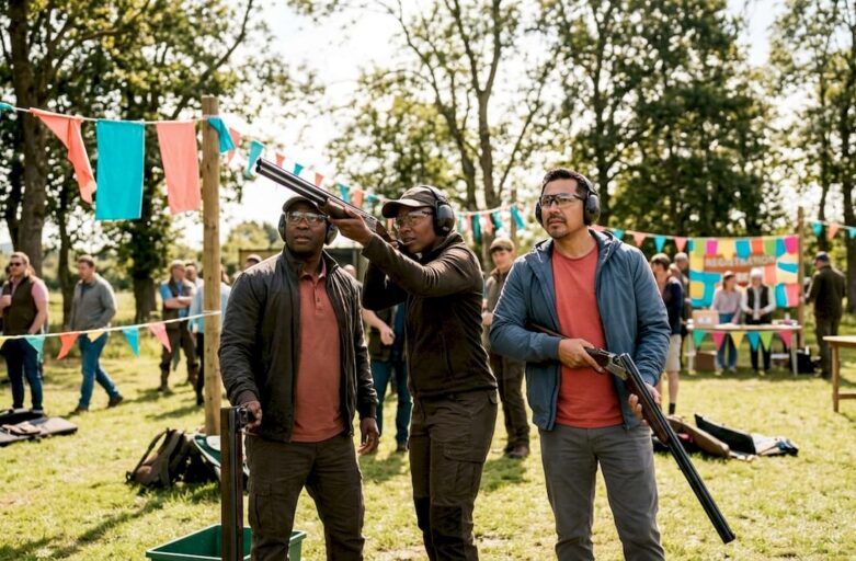 Participants aiming at clay targets outdoors
