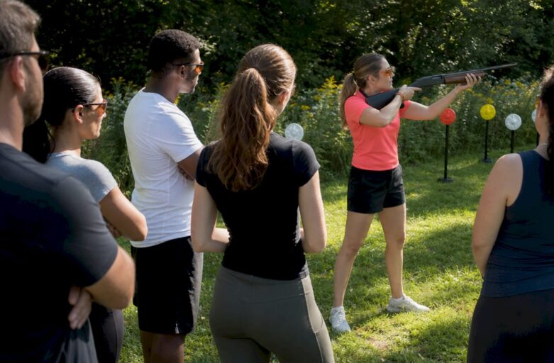 Laser clay instructor briefing participants outdoors
