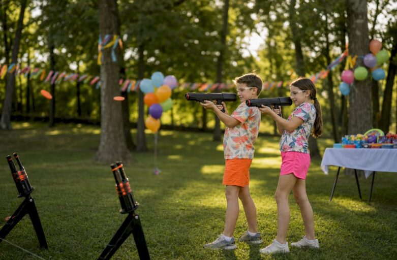 Children enjoying laser clay shooting party outdoors