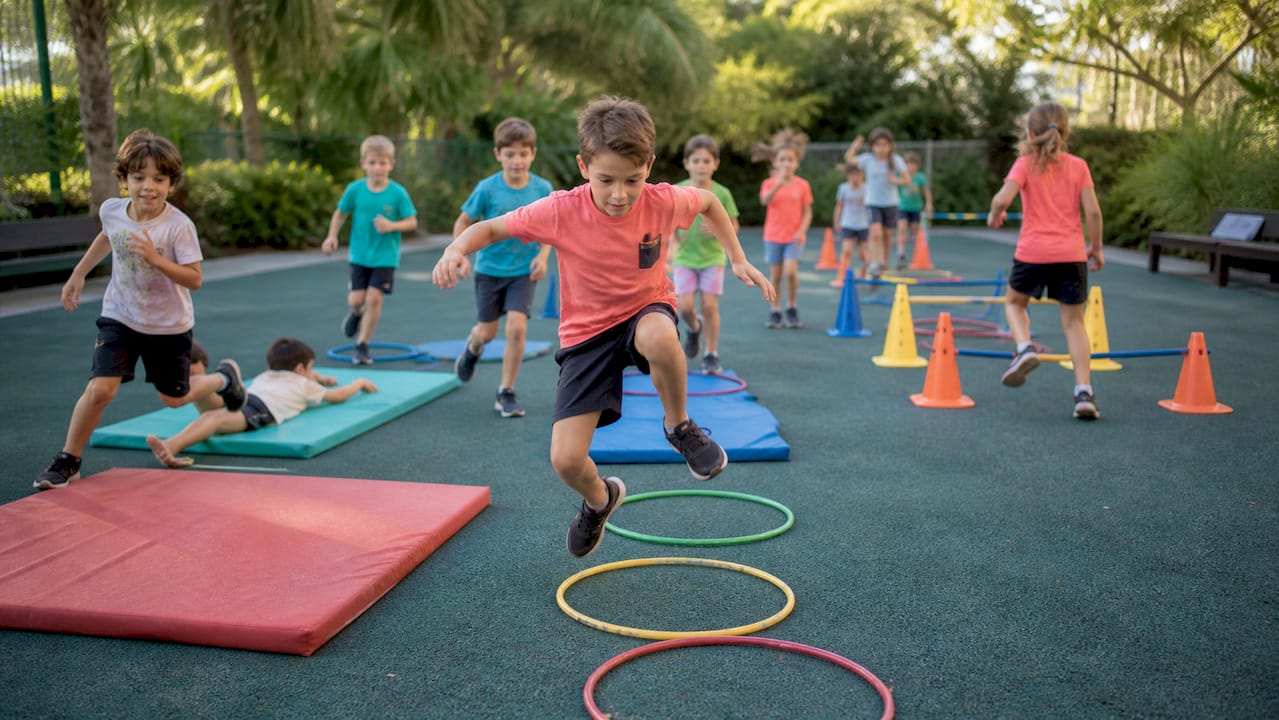 Kids running obstacle course relay outdoors