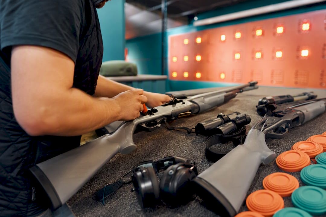 Hands adjusting laser shotguns at event
