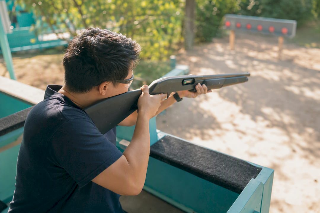 Corporate team member aiming laser shotgun mid-relay