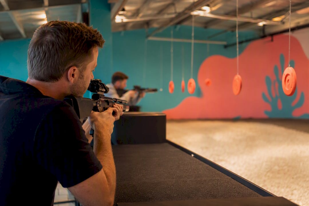 Indoor covered laser clay shooting mid-action