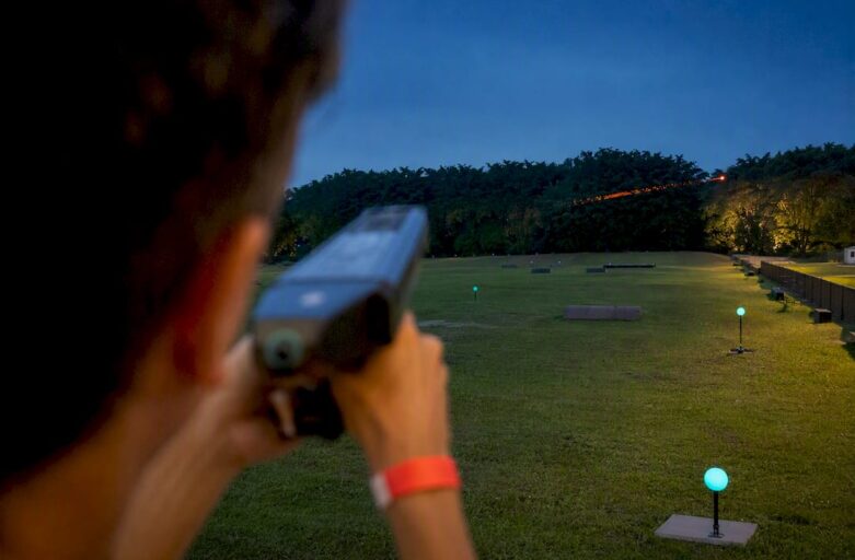Participants tracking clay targets at sunset