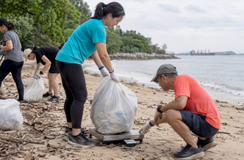 Corporate team weighing collected shoreline waste