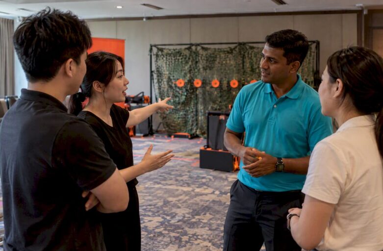 Corporate team debriefs after laser-clay icebreaker