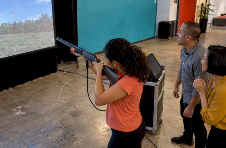 Colleagues take turns at laser clay shooting