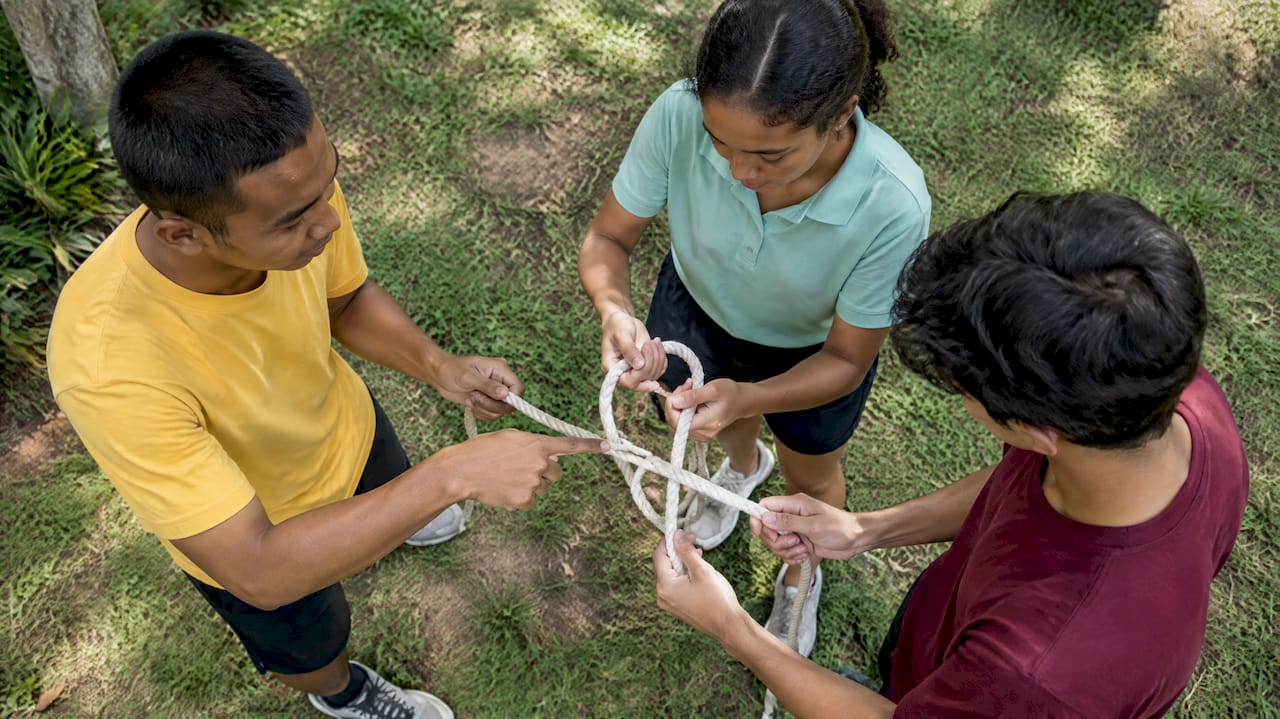 Students solve a shared-rope leadership puzzle